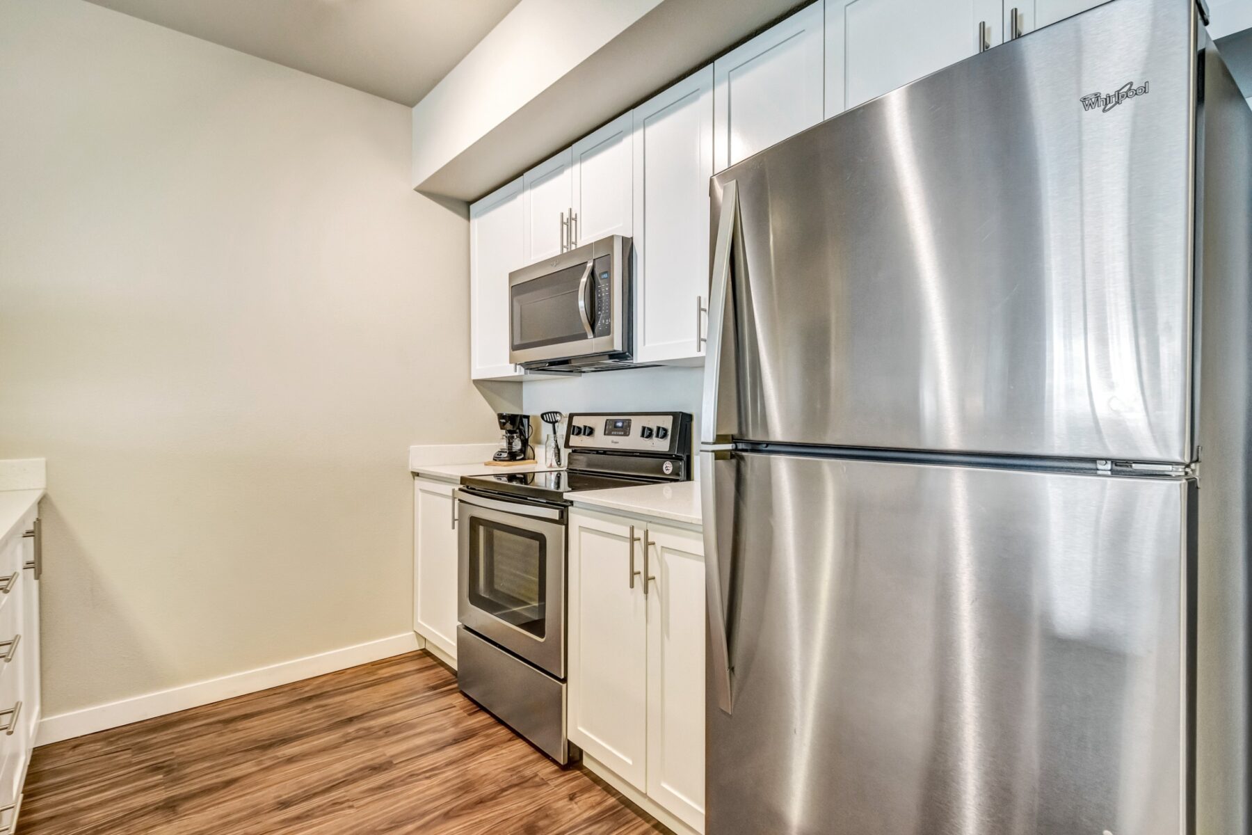 Kitchen with stainless steel appliances, all white cabinets and countertops