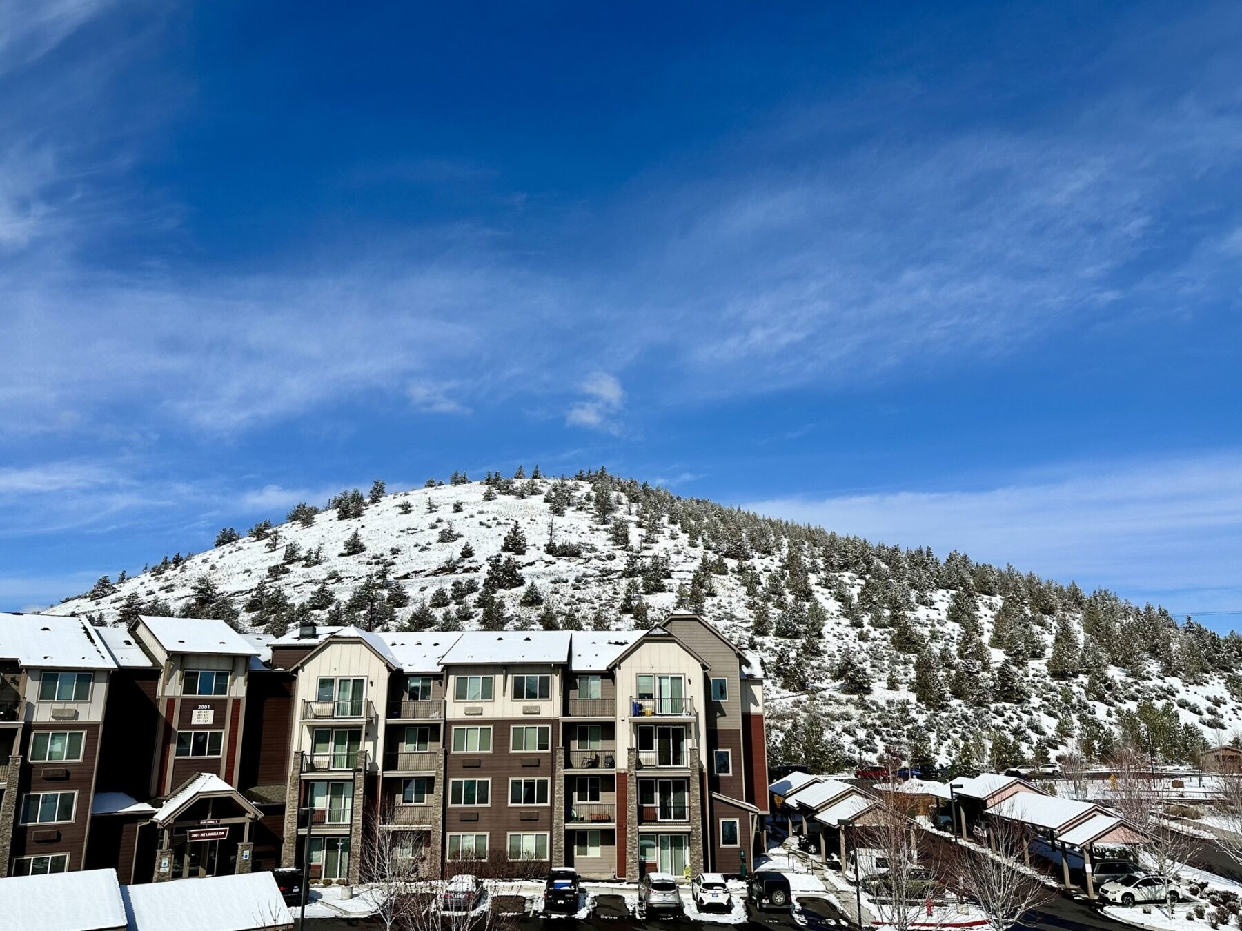 exterior aerial shot of apartment complex with snowcapped mountains in the distance