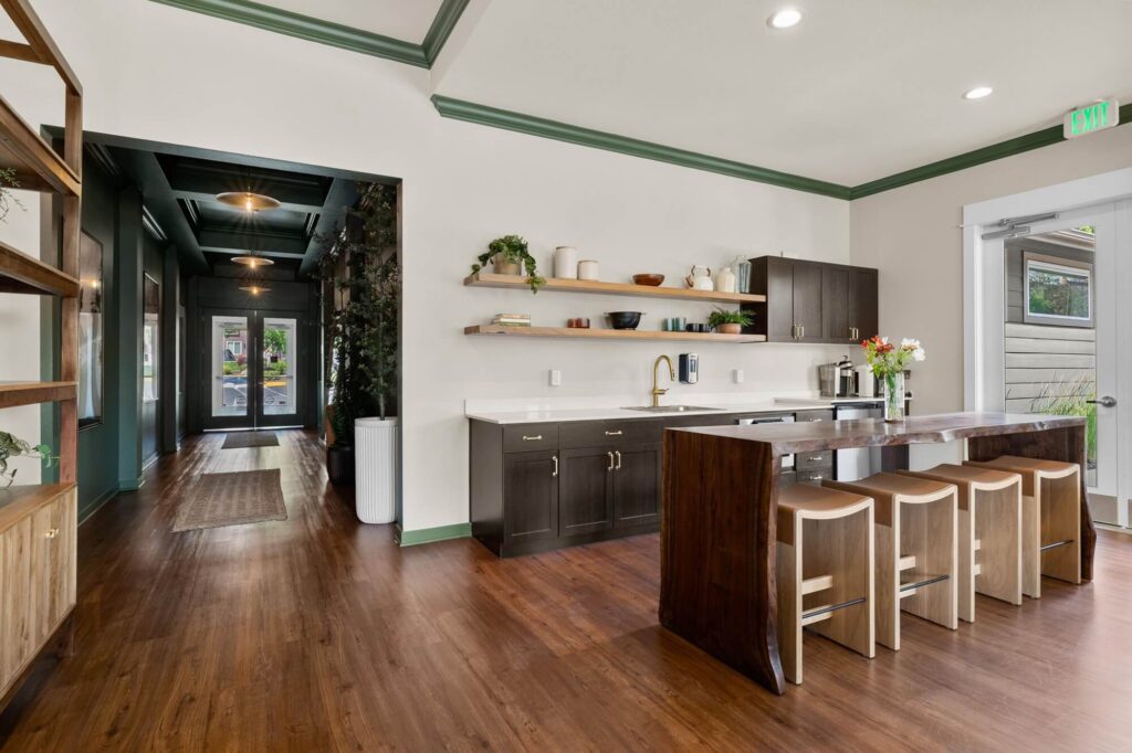 Clubhouse kitchen area with bar seating, sinks, cabinets and appliances