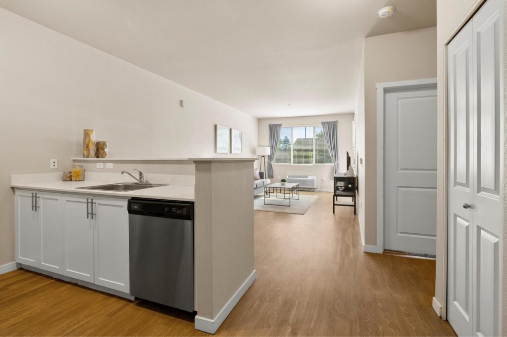 Kitchen counter with bar height separation with sink and dishwasher overlooking living room space