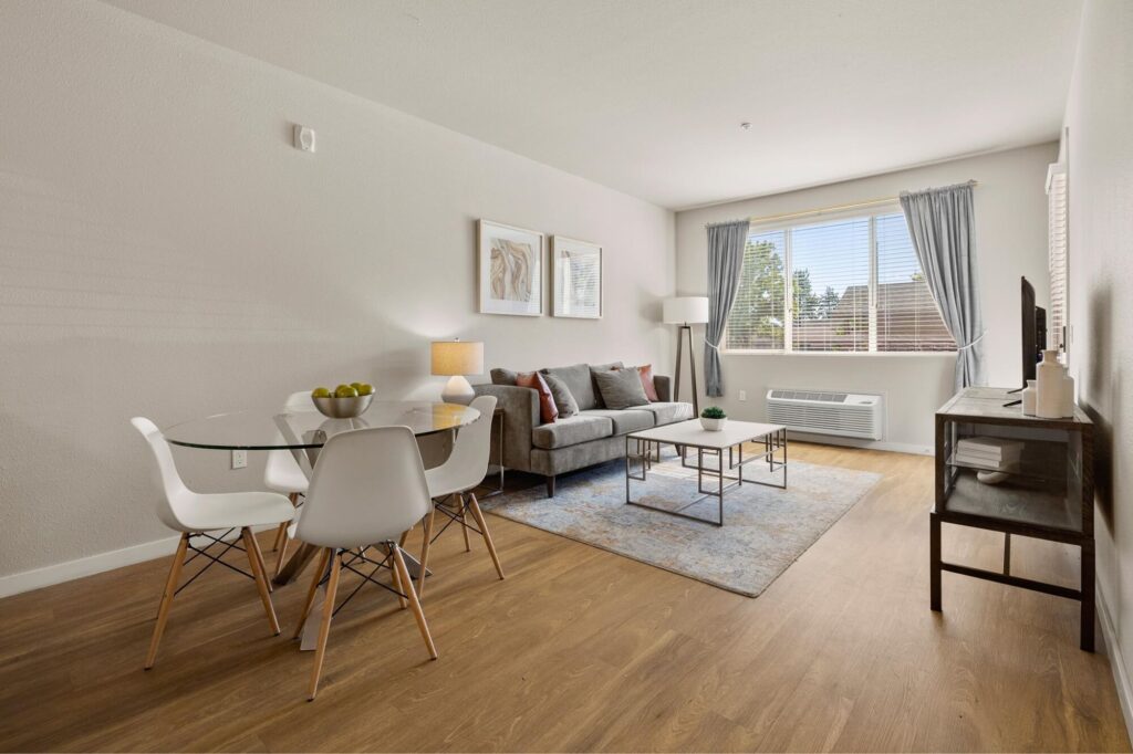 Living and dining room space with large window and lounge seating