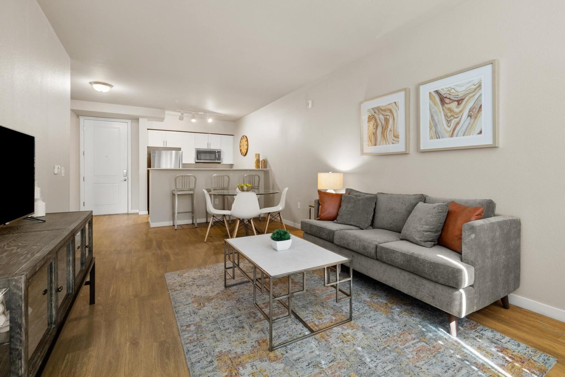 Living room with sofa and various decorations next to kitchen and dining space