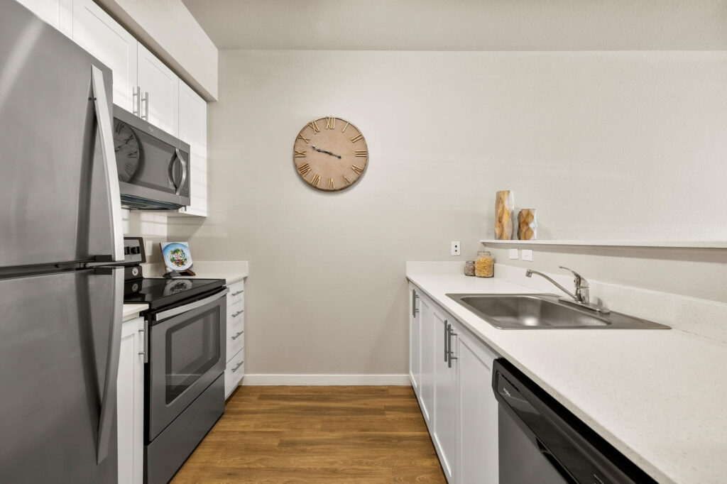 Kitchen with stainless steel appliances and white cabinets and counter tops
