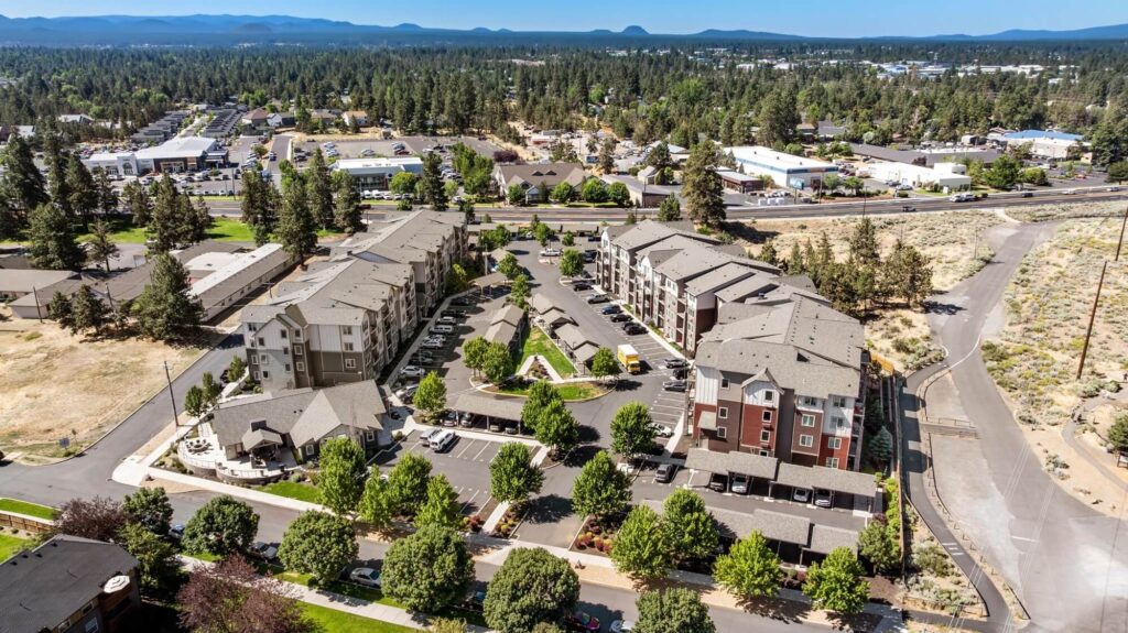 Exterior view of apartment complex with parking lot and covered parking
