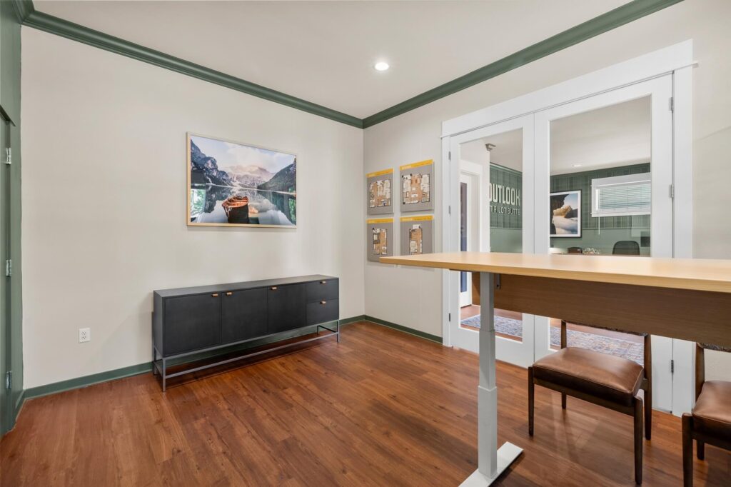 Meeting reception area with standing desk and chairs with various decor and floor plan types mounted on the wall