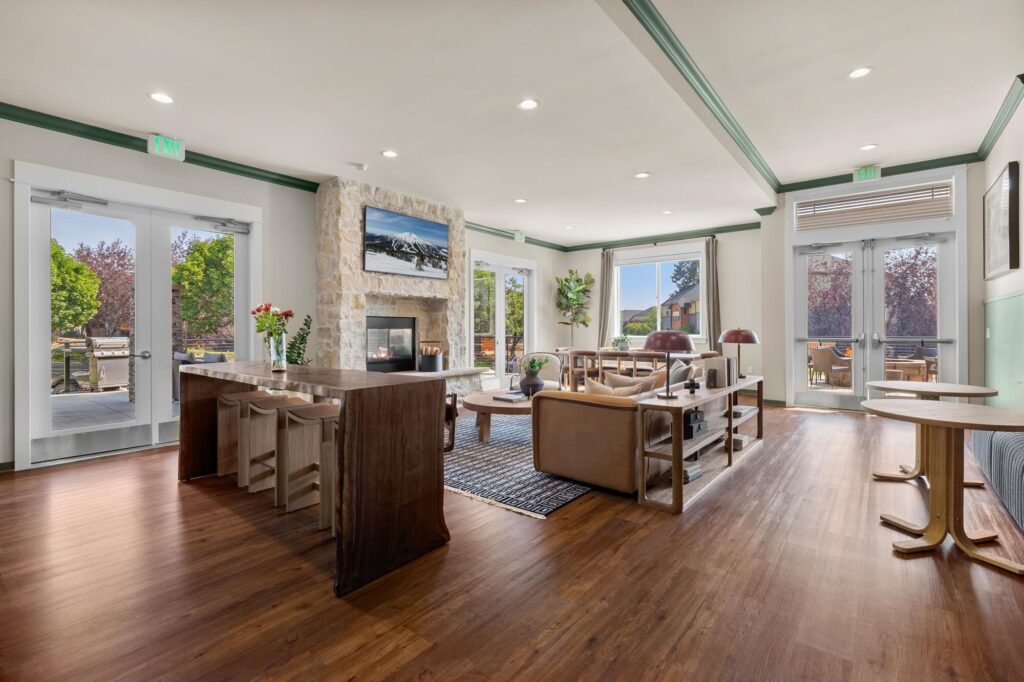 Clubhouse interior with lounge seating around a fireplace with television mounted above it