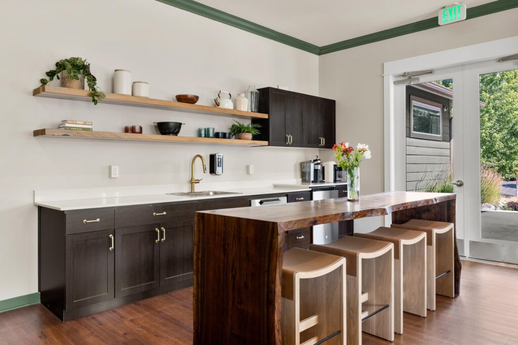 Clubhouse kitchen area with bar seating, sinks, cabinets and appliances