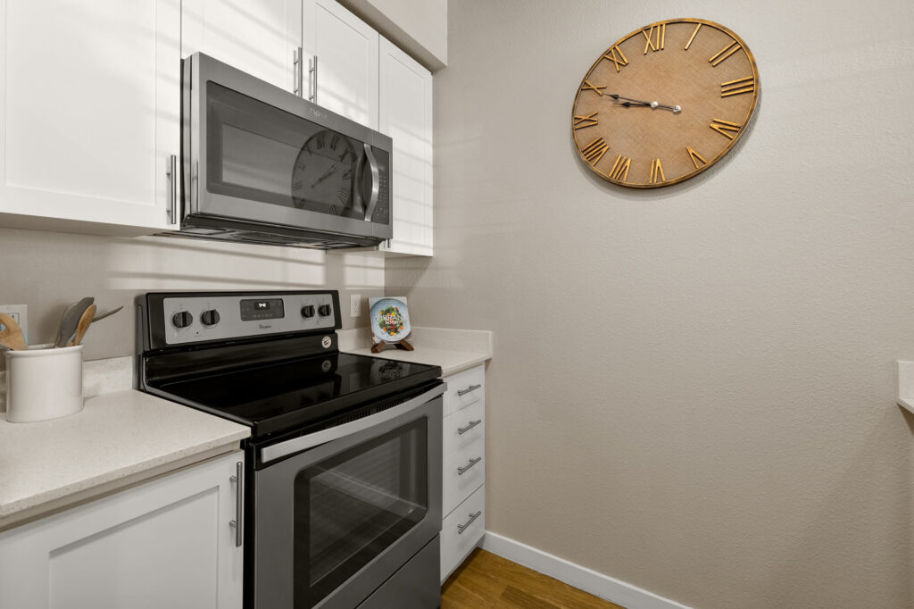 Kitchen with stainless steel oven and microwave appliances with white cabinets and countertops