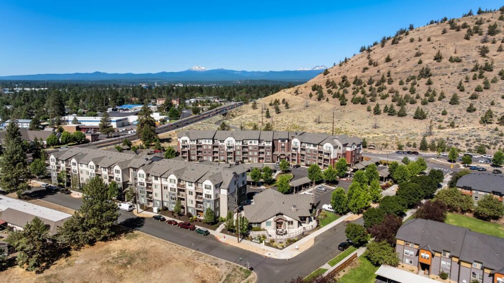 Exterior view of apartment complex with parking lot and covered parking